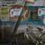 A weathered Indian street wall layered with printed posters, a bicycle propped against it