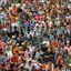 A densely packed crowd of thousands seated at an outdoor gathering in India