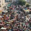 An aerial view of a dense Indian market street packed with stalls and people