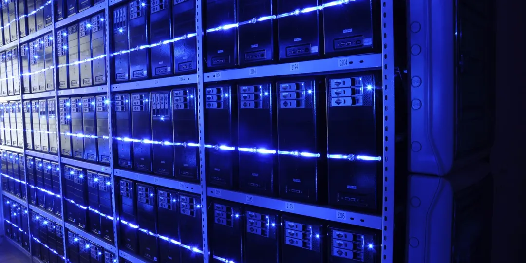 Rows of server racks lit blue inside a data centre