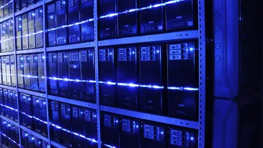 Rows of server racks lit blue inside a data centre