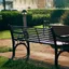 Two empty park benches in low evening light