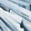 A tightly stacked row of folded newspapers seen edge-on