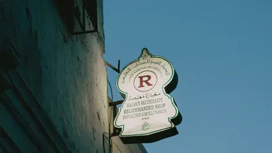 A shop sign carrying the same message in Arabic, French, English and German