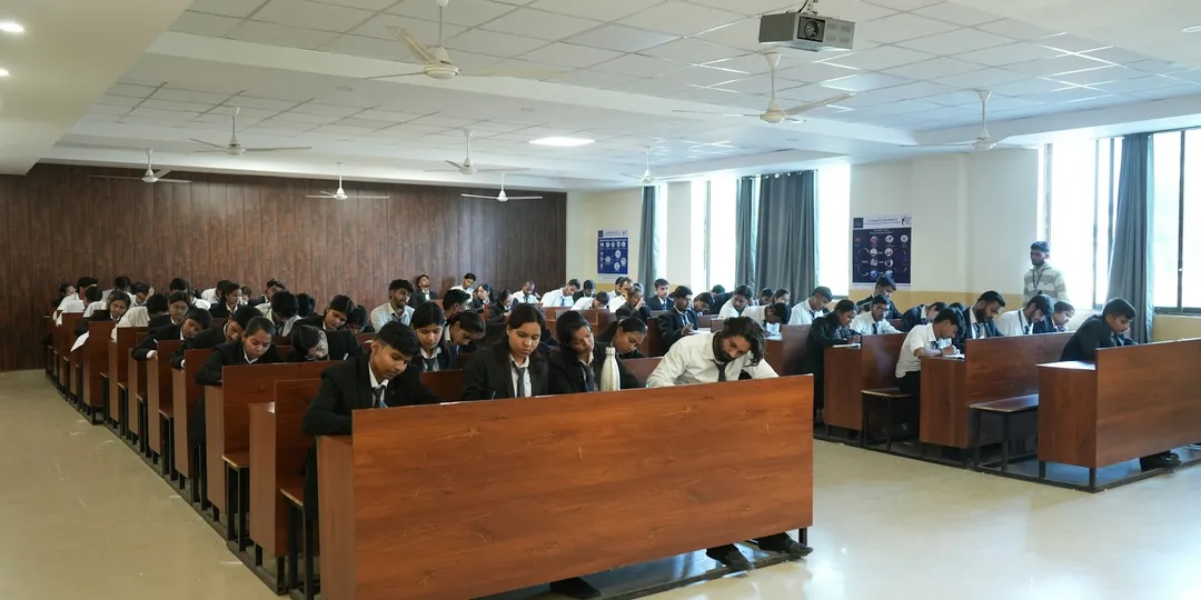 Rows of students seated at desks in a large lecture hall