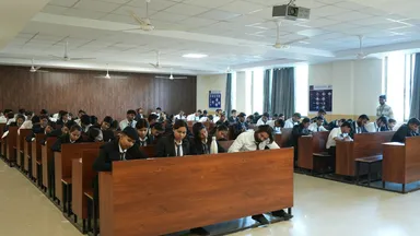 Rows of students seated at desks in a large lecture hall