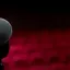 A microphone on a stand before rows of empty red theatre seats