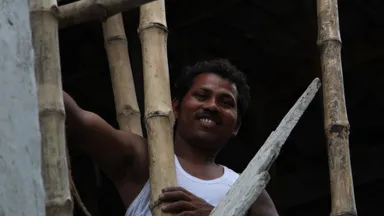 A construction worker on a bamboo-scaffolded building site in India