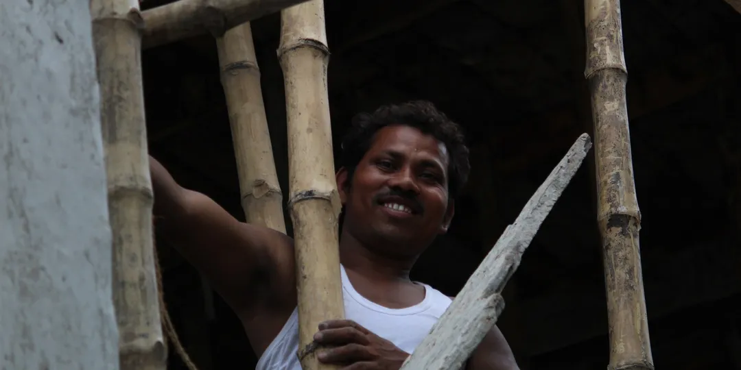 A construction worker on a bamboo-scaffolded building site in India