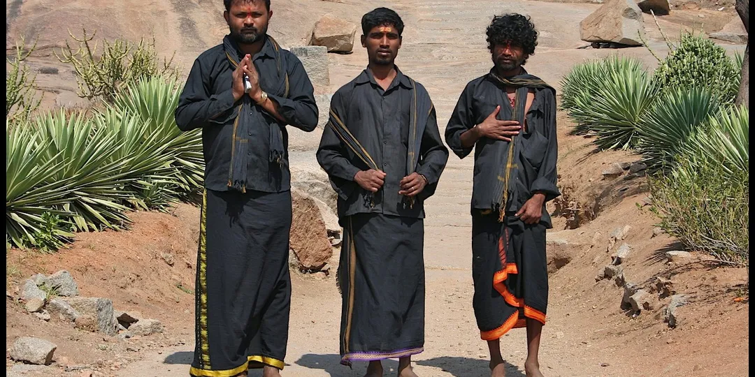 Ayyappa devotees in traditional black pilgrimage attire on the path to Sabarimala