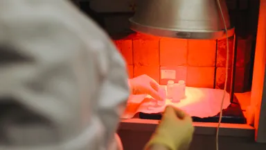 A laboratory scientist handling samples under red light