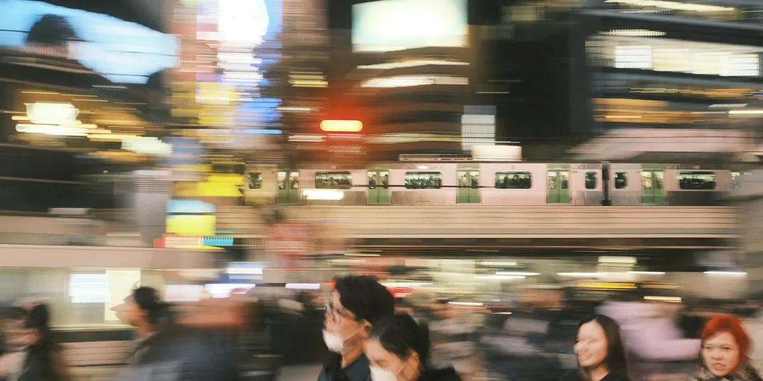 A crowded railway platform in motion blur as a train passes