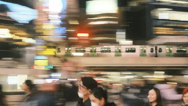 A crowded railway platform in motion blur as a train passes