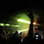 Silhouetted concertgoers raise their hands toward a brightly lit stage.