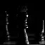 Chess pieces on a board in dramatic low light