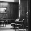 An empty consulting room with chairs and a desk, in black and white